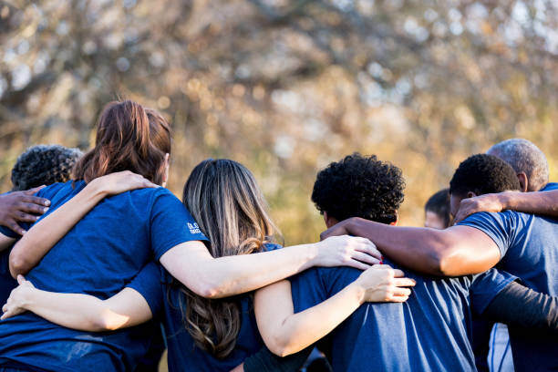 Volunteers standing together in a supportive group huddle